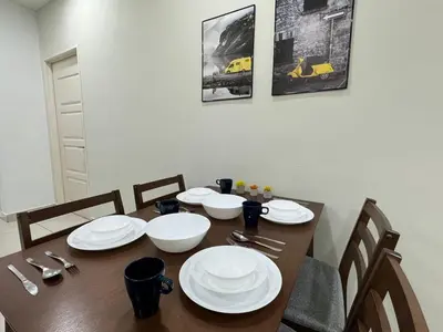 a dining room table with white plates on it at Mansion One at Gurney Drive Georgetown by 3C in George Town
