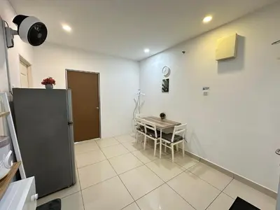 a kitchen and dining room with a table and a refrigerator at Mansion One at Gurney Drive Georgetown by 3C in George Town