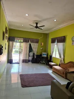 a living room with a couch and a ceiling fan at de'berah homestay penaga in Penaga
