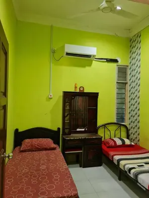 a green room with two beds and a desk at de'berah homestay penaga in Penaga