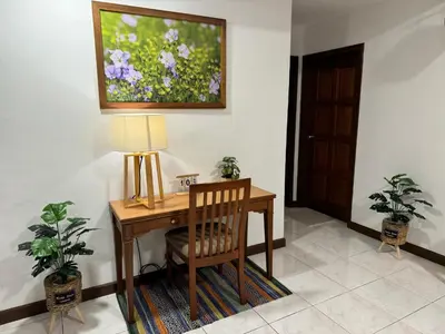 a desk with a lamp and a painting on the wall at Sevenseas Family Home Copthorne Cameron Highland in Brinchang