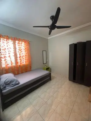 a bedroom with a bed and a ceiling fan at Homestay Permai Lake View in Kampong Batu Lapan