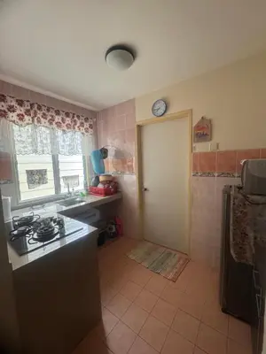 a kitchen with a stove and a sink and a door at Homestay Permai Lake View in Kampong Batu Lapan