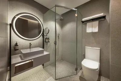 a bathroom with a toilet and a sink and a mirror at Citadines Connect Cecil Georgetown Penang in George Town