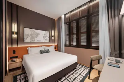 a bedroom with a white bed and a chair at Citadines Connect Cecil Georgetown Penang in George Town
