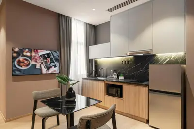 a kitchen with a table and a refrigerator at Citadines Connect Cecil Georgetown Penang in George Town