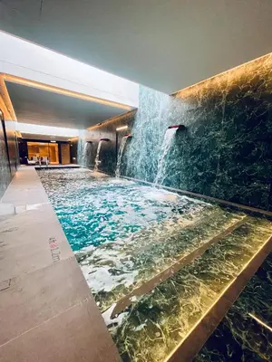 a large swimming pool with a waterfall in a building at Citadines Connect Cecil Georgetown Penang in George Town