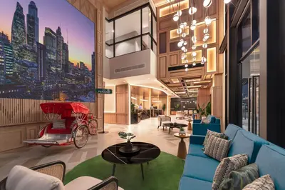 a lobby with blue furniture and a mural of a city at Citadines Connect Cecil Georgetown Penang in George Town