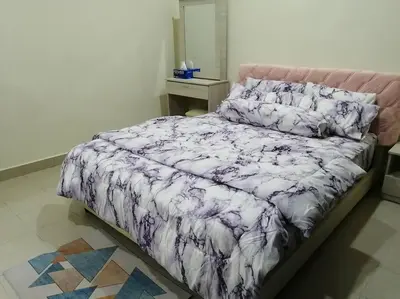 a bed with a purple and white comforter in a bedroom at 4-Bedroom Homestay in Taiping, Perak in Kamunting