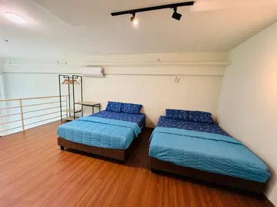two beds in a room with blue pillows at The CEO Suits in Bayan Lepas