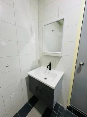 a white bathroom with a sink and a mirror at The CEO Suits in Bayan Lepas