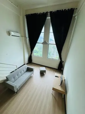 a living room with a couch and a large window at The CEO Suits in Bayan Lepas