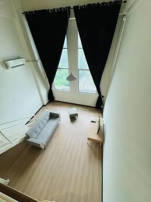 a living room with a couch and a large window at The CEO Suits in Bayan Lepas