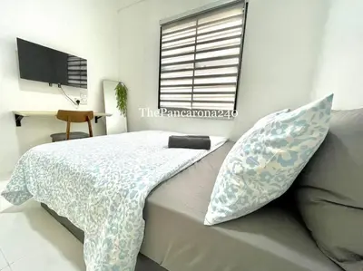 a bedroom with a bed with pillows and a window at The Pancarona240 in Seri Iskandar