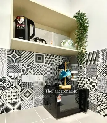 a kitchen with black and white tiles on the wall at The Pancarona240 in Seri Iskandar