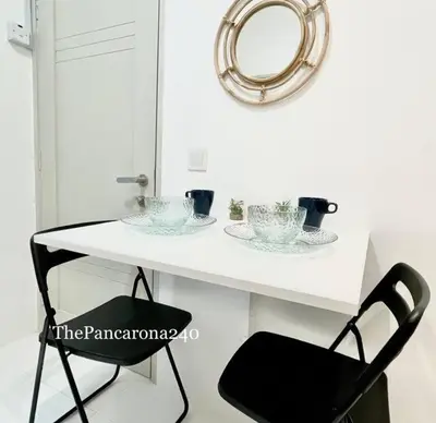 a white table with a black chair and a mirror at The Pancarona240 in Seri Iskandar