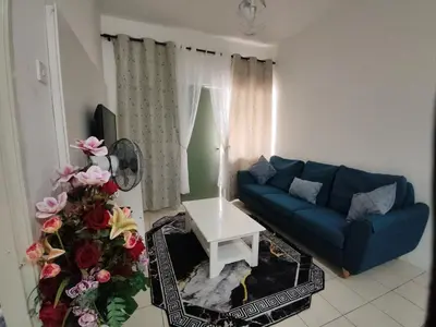 a living room with a blue couch and a table at Ian's Homestay Tanah Rata C Highlands in Tanah Rata