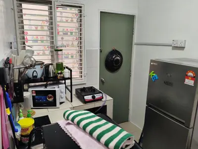 a kitchen with a refrigerator and a table with a microwave at Ian's Homestay Tanah Rata C Highlands in Tanah Rata