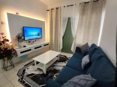 a living room with a blue couch and a tv at Ian's Homestay Tanah Rata C Highlands in Tanah Rata