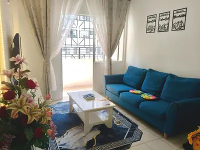 a living room with a blue couch and a table at Ian's Homestay Tanah Rata C Highlands in Tanah Rata