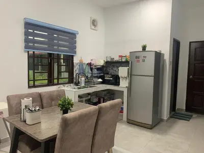 a kitchen with a table and a refrigerator at HOMeSTAY DAMIA - Islam Homestay Only in Teluk Intan