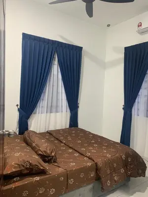 a bedroom with a bed with blue drapes at HOMeSTAY DAMIA - Islam Homestay Only in Teluk Intan