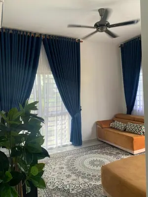 a bedroom with blue curtains and a large window at HOMeSTAY DAMIA - Islam Homestay Only in Teluk Intan