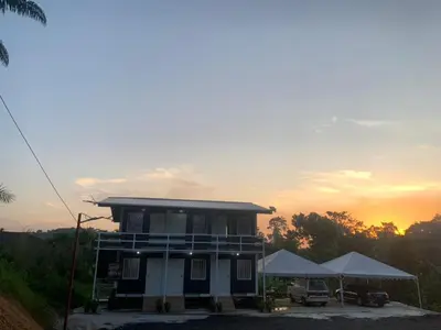 a small house with a sunset in the background at Farhani Cabin Stay in Kampong Batu Lima