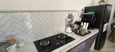 a kitchen with a counter with a stove top oven at AMI Homestay & Guest House in Gua Musang