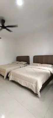 two beds in a room with a ceiling fan at AMI Homestay & Guest House in Gua Musang