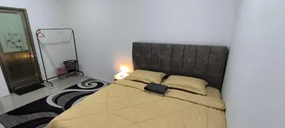a bedroom with a bed with a headboard and a mirror at AMI Homestay & Guest House in Gua Musang