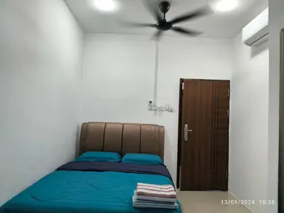 a bedroom with a bed and a ceiling fan at AMI Homestay & Guest House in Gua Musang