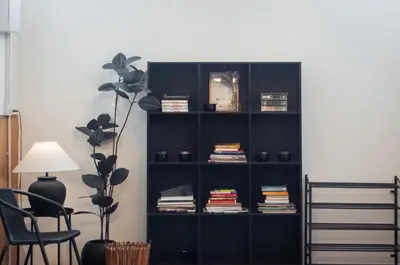 a black book shelf with books and a chair at The Terraces by Aayu - 2 mins walk to Chulia Street in George Town