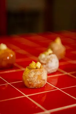 a group of three donuts on a red table at The Terraces by Aayu - 2 mins walk to Chulia Street in George Town