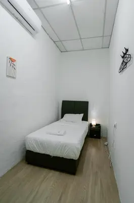 a bedroom with a bed in a white room at The Terraces by Aayu - 2 mins walk to Chulia Street in George Town