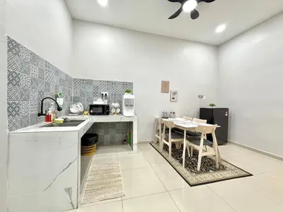 a kitchen with a sink and a table with chairs at SFS Family Homestay Kulim in Kulim