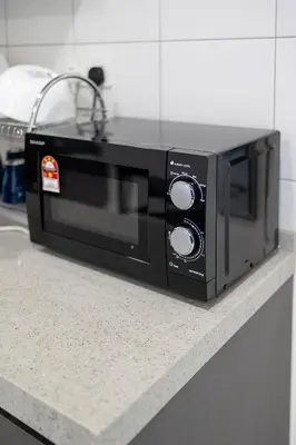 a black microwave sitting on top of a counter at The Sun Executive #BayanLepas #QueensbayMall #8 in Bayan Lepas