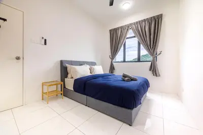 a bedroom with a bed with a blue comforter and a window at The Sun Executive #BayanLepas #QueensbayMall #13 in Bayan Lepas