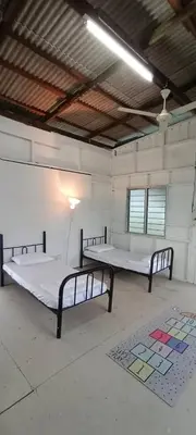 a room with two beds in a room with a rug at Bukit Limau rest house Merbau in Taiping