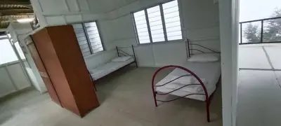 a room with two beds and a chair in it at Bukit Limau rest house Merbau in Taiping