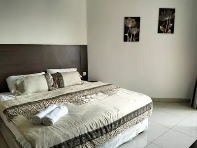 a bed in a bedroom with two pictures on the wall at Marina Heights Home Suite Teluk Batik in Lumut