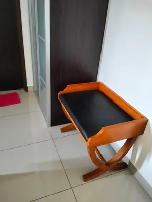 a wooden chair sitting on the floor in a room at Marina Heights Home Suite Teluk Batik in Lumut