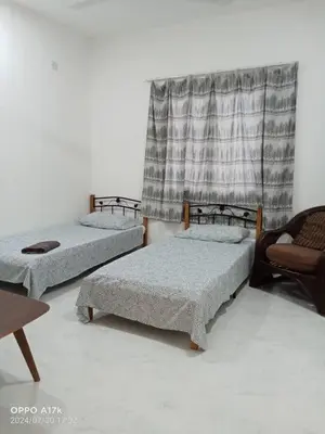 a room with two beds and a chair and a window at Bilik Umar in Gerik