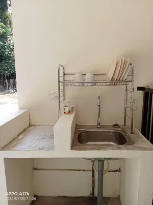 a kitchen sink with a metal shelf above it at Bilik Umar in Gerik