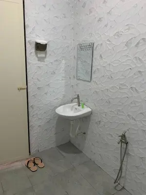 a white bathroom with a sink and a mirror at Bilik Umar in Gerik