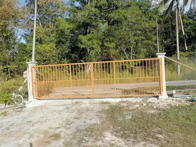 a orange gate in front of a fence at Bilik Ubaidillah in Gerik