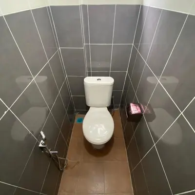 a bathroom with a toilet in a tiled wall at Ipoh Apartment Suites in Ipoh