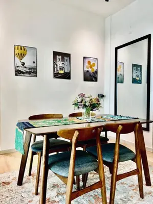 a dining room table with a vase of flowers on it at 2BR LaPrimo Homestay Bandar Meru Raya Ipoh in Ipoh