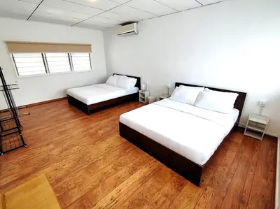 a bedroom with two beds and wooden floors at PUTIH Ipoh SaltWater Pool BBQ 5Bed4Bath 19pax in Ipoh