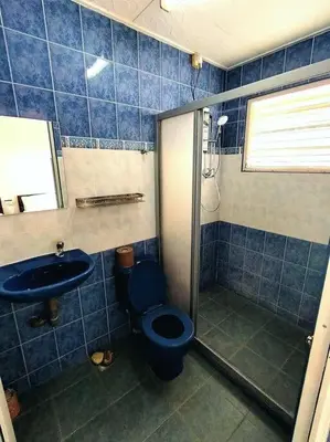 a blue tiled bathroom with a toilet and a sink at PUTIH Ipoh SaltWater Pool BBQ 5Bed4Bath 19pax in Ipoh